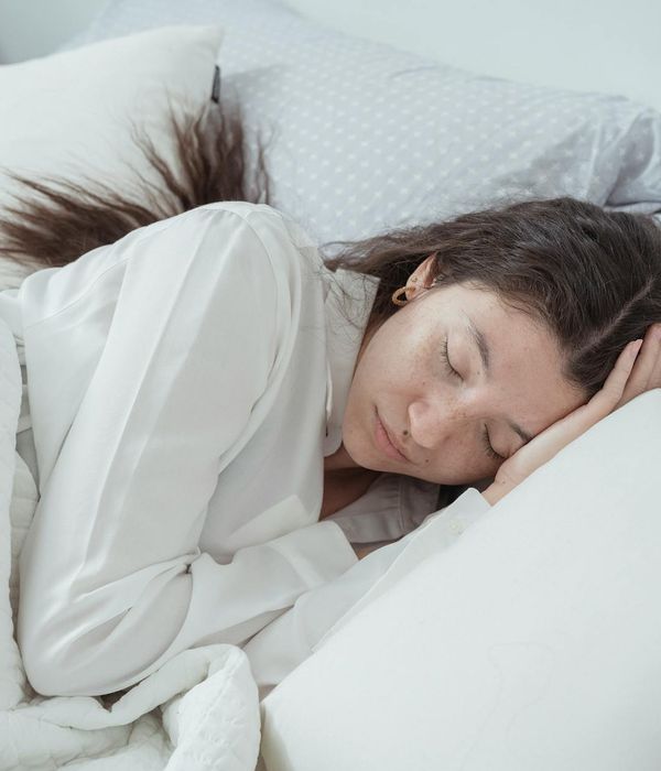 Woman meditating peacefully in a cozy room at night.